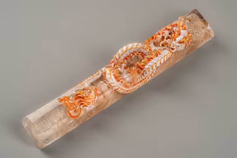 Intricately carved orange dragon in crystal cylinder.