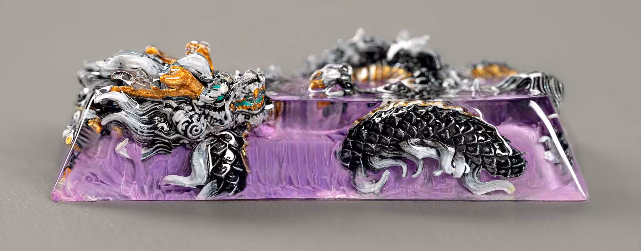 Intricate silver dragon sculpture on purple amethyst base.